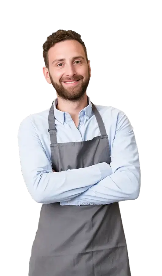 Smiling male small business owner in a grey apron with arms crossed, exploring business funding options.